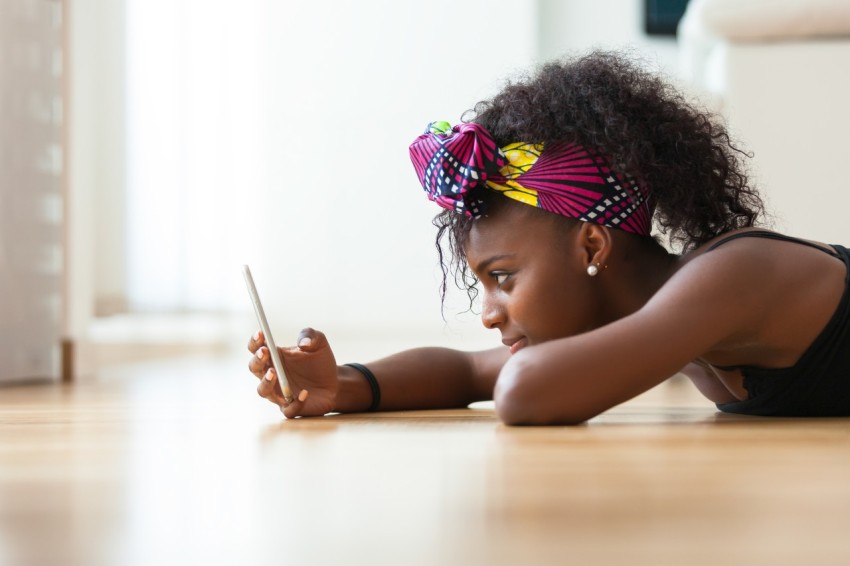 Tanzanian woman sending a text message on a mobile phone
